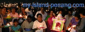 A family of devotees with lighted dish in Chariot Procession Teluk Bahang Penang