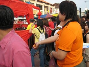 Lady throwing orange during chap goh meh in penang