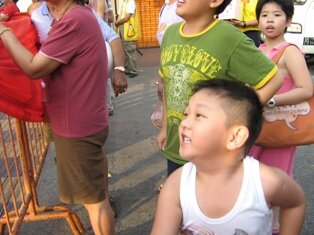 Boy throwing oranges during chap goh meh in penang